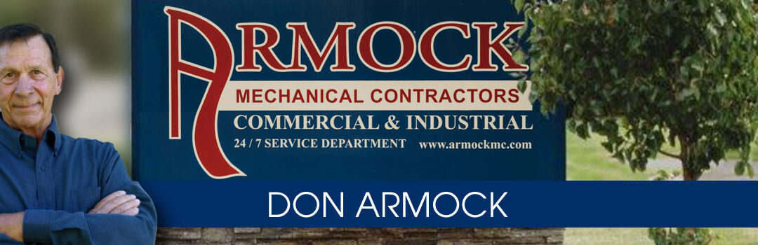 Founder Don Armock photo w/ bldg sign