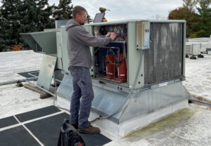 tech working on roof unit