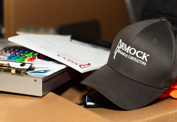 Armock logo ballcap on desk next to field notes